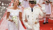 Sob chuva de pétalas de rosas brancas, o chefe de Estado de Mônaco e a ex-nadadora sul-africana irradiam felicidade ao deixar o Palácio Magnífico após cerimônia religiosa. - Reuters