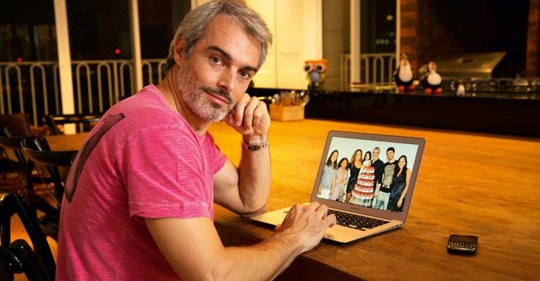 Em casa, ele vê foto de CARAS da família unida, incluindo Giovana e Gabriel, os filhos mais velhos de Daniela, no aniversário dela, em 2012. - Caio Guimarães