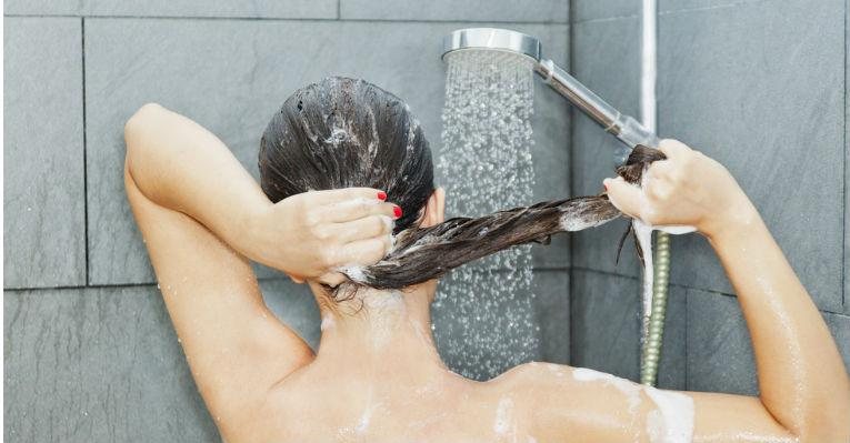 Para amenizar o teor de óleo nos fios, lave o cabelo com água morna - Shutterstock