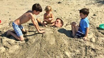 Tom Brady é enterrado na areia pelos filhos - Facebook/Reprodução