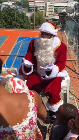 Nego do Borel vestido de Papai Noel fazendo doações
