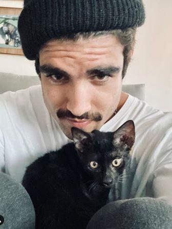 Caio Castro segurando gato de estimação no colo