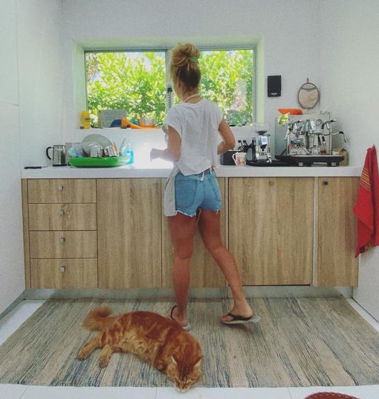 Carolina Dieckmann lava louça com companhia do gato
