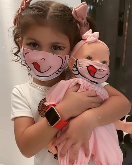 Bella Falconi mostra filha e boneca com máscaras