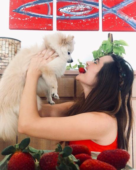 Juliana Paiva come morangos coladinha com seu cachorro 