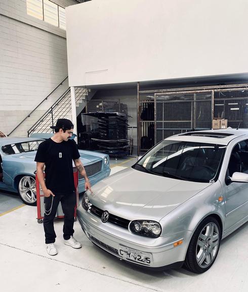 Caio Castro posa em garagem com carros clássicos