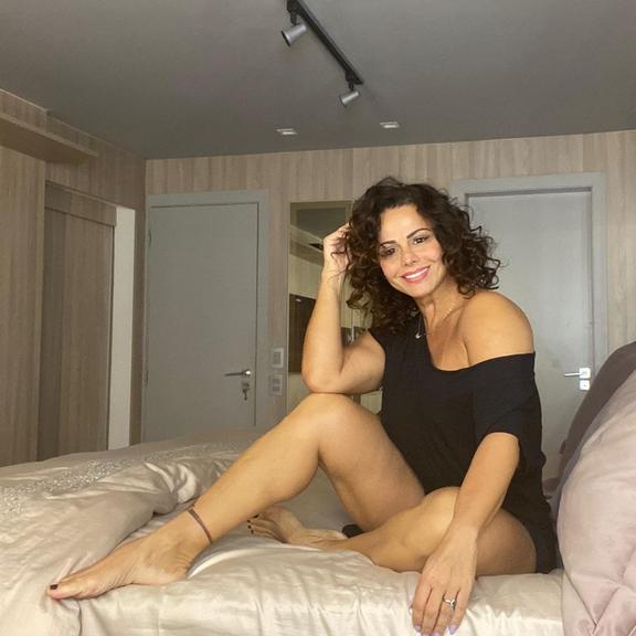 Viviane Araújo surge só de camiseta em cima da cama