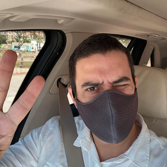 André Marques posa de máscara no carro a caminho do trabalho