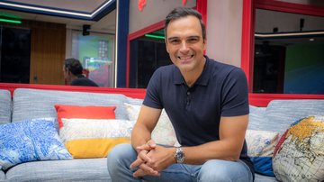 O apresentador Tadeu Schmidt na casa do BBB 23, sentado na sala - Foto: Divulgação/Globo