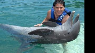 Cesar na água com um golfinho em Cancun, México