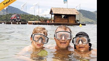 Pedro, Marcello e Diogo nadam no mar da Ilha de CARAS, com o Acqua Lounge Fiat ao fundo