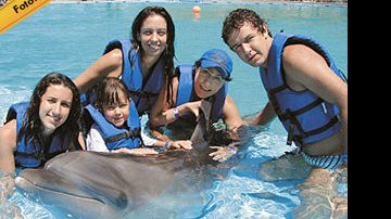 Nas águas claras do Cabo Dolphins, o apresentador e a família se divertem com os golfinhos.