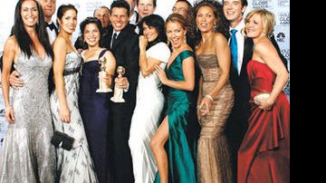 América Ferrera com seu Globo de Ouro e a produtora Salma Hayek (de branco) entre os colegas de Ugly Betty
