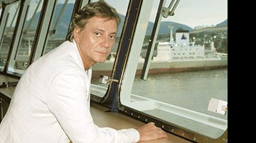 O cantor observa o mar de Santos da janela do navio Grand Mistral