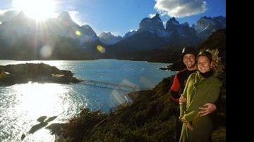 No parque Torres del Paine, tendo o lago Pehoé e os Cuernos do Paine ao fundo, o casal admira o dia ensolarado e o belíssimo céu azul. - Jaime Bórquez