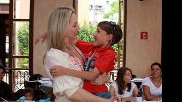 Adriana Colin segura no colo criança do GRAAC durante almoço na Pizzaria Esperanza - Divulgação