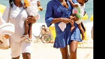 Ao lado da babá Lita, com Maria no colo, Glória Maria deixa a praia do Leblon fazendo graça para a caçula, Laura. - Wallace Barbosa/Ag. News
