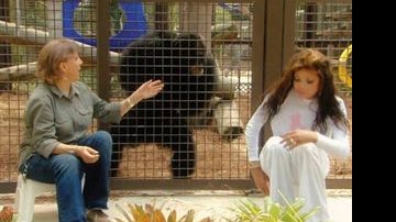 Na frente da jaula de Bubbles, a instrutora do santuário para símios explica para La Toya a rotina do animal. - QUEEN