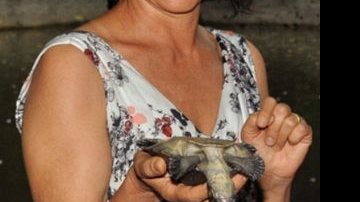 Encantada com a delicadeza da tartarugada-amazônia, Cássia participa da tradicional cerimônia de batismo... - URELAN MONTEIRO