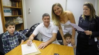 De branco, eles assinam a união civil entre os filhos e diante da escrevente Ana Paula Borges, em SP. - ARQUIVO PESSOAL