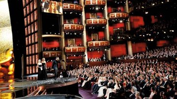 Christian Bale sobe ao palco para receber seu Oscar da elegante Reese Whiterspoon. - GETTY IMAGES E STARTRAKS