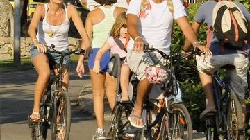 Marcos leva a filha, Júlia, na garupa da bicicleta seguido de uma amiga.