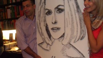 O artista entrega o quadro a Bianca Rinaldi - Divulgação