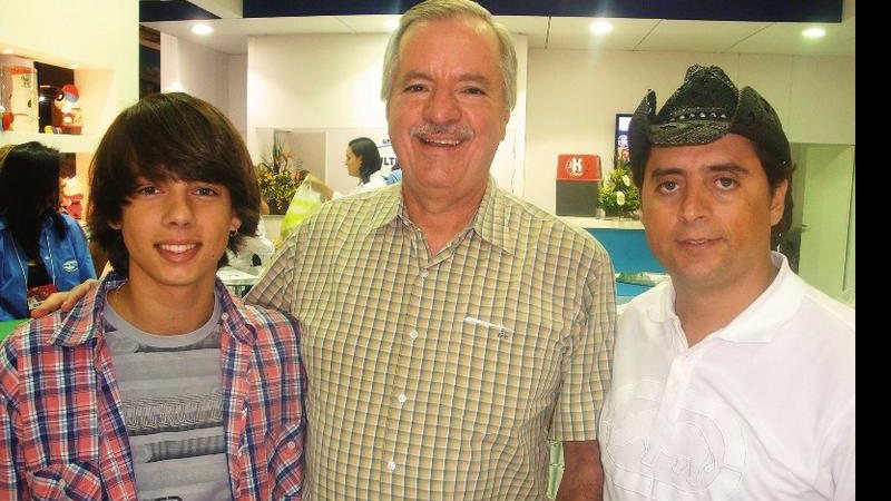 Os cantores Maury Lima e o pai, Mauri, ladeiam José Roberto Nicolau, diretor de loja de brinquedos, em SP. - ANDRÉ VICENTE