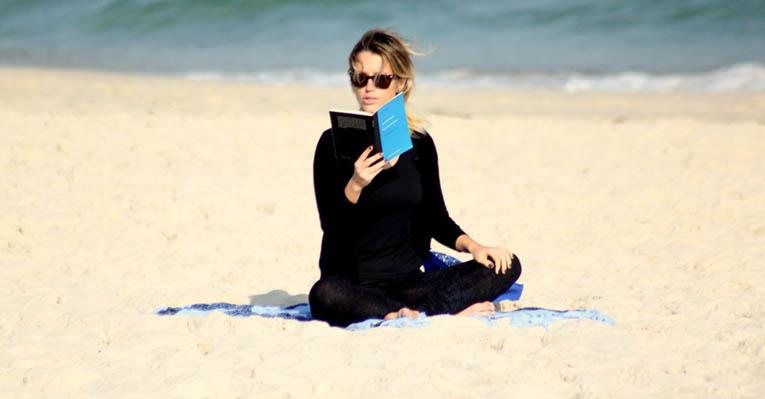 Preta foi a cor escolhida por Juliana Didone (26) para ir à praia no Rio. Sozinha, a atriz aproveitou para colocar a leitura em dia. - Photo Rio News