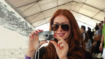 Com sua câmera na área vip da Arena Copacabana, a atriz acompanha os lances do jogo de futebol de areia. - Selmy Yassuda/Artemisia Fot. e Com