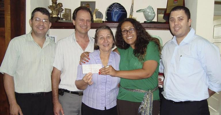 Clóvis Boufleur, Nelson Arns Neumann e a freira Vera Lúcia Altoé recebem doação para a Pastoral da Criança de Lilia Andrade e Ricardo Matiusso, ambos de rede de pizzarias, em Curitiba.