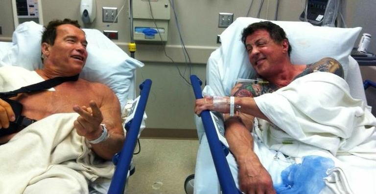 Arnold Schwarzenegger e Sylvester Stallone conversam em camas de hospital - Reprodução/Twitter