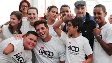 Fernando Fernandes e Mario Travaglini entre as crianças da AACD - Divulgação