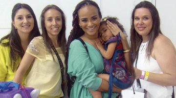 Vanessa Freitas, Larissa Panunzzio e Camila Silva, à dir., oferecem chocolates de sua loja à cantora Luciana Mello e a filha, Nina, em evento de moda, em SP. - -