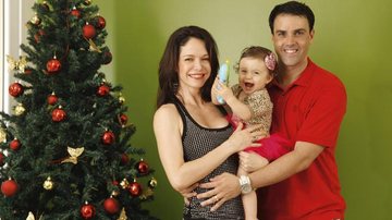 Na sala de casa, diante da árvore de Natal, Babi e Felipe se divertem com a gargalhada da menina. - -