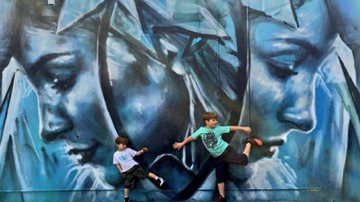 Davi e Rafael, filhos de Claudia Leitte, posam em frente à obra de arte com o rosto da mãe - Twitter/Reprodução