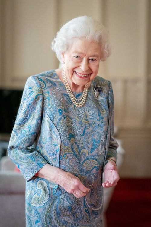 A monarca estava sorridente no Palácio de Windsor usando um vestido azul