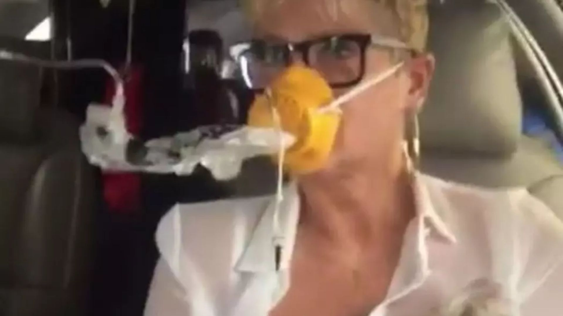 Xuxa com uma máscara de oxigênio amarela em avião