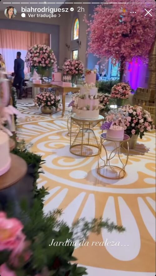 As flores rosas se espalham ao longo do salão da festa e chegam às portas da sede da celebração de aniversário, que ocorrerá em um castelo de verdade. 
