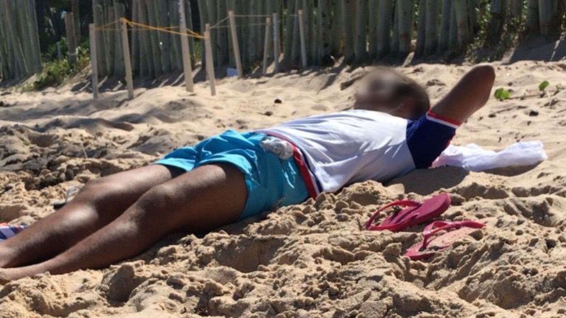 Marcelo Sangalo deitado na areia 