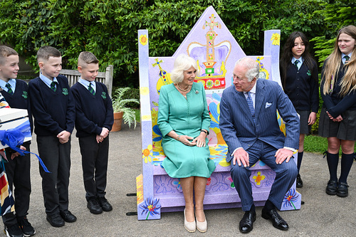 Nos jardins do castelo, Charles e Camilla interagiram com alguns estudantes da Escola Primária de Blythefield que foram vencedores em uma competição para construir um banco que celebrava a coroação. 