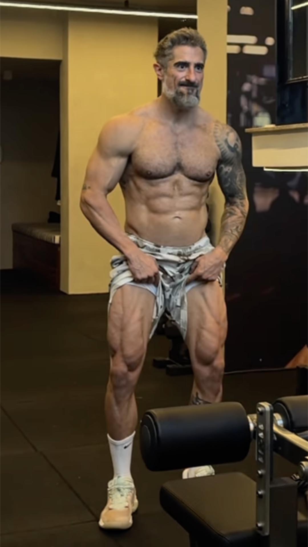 Marcos Mion levanta a bermuda para mostrar as pernas musculosas