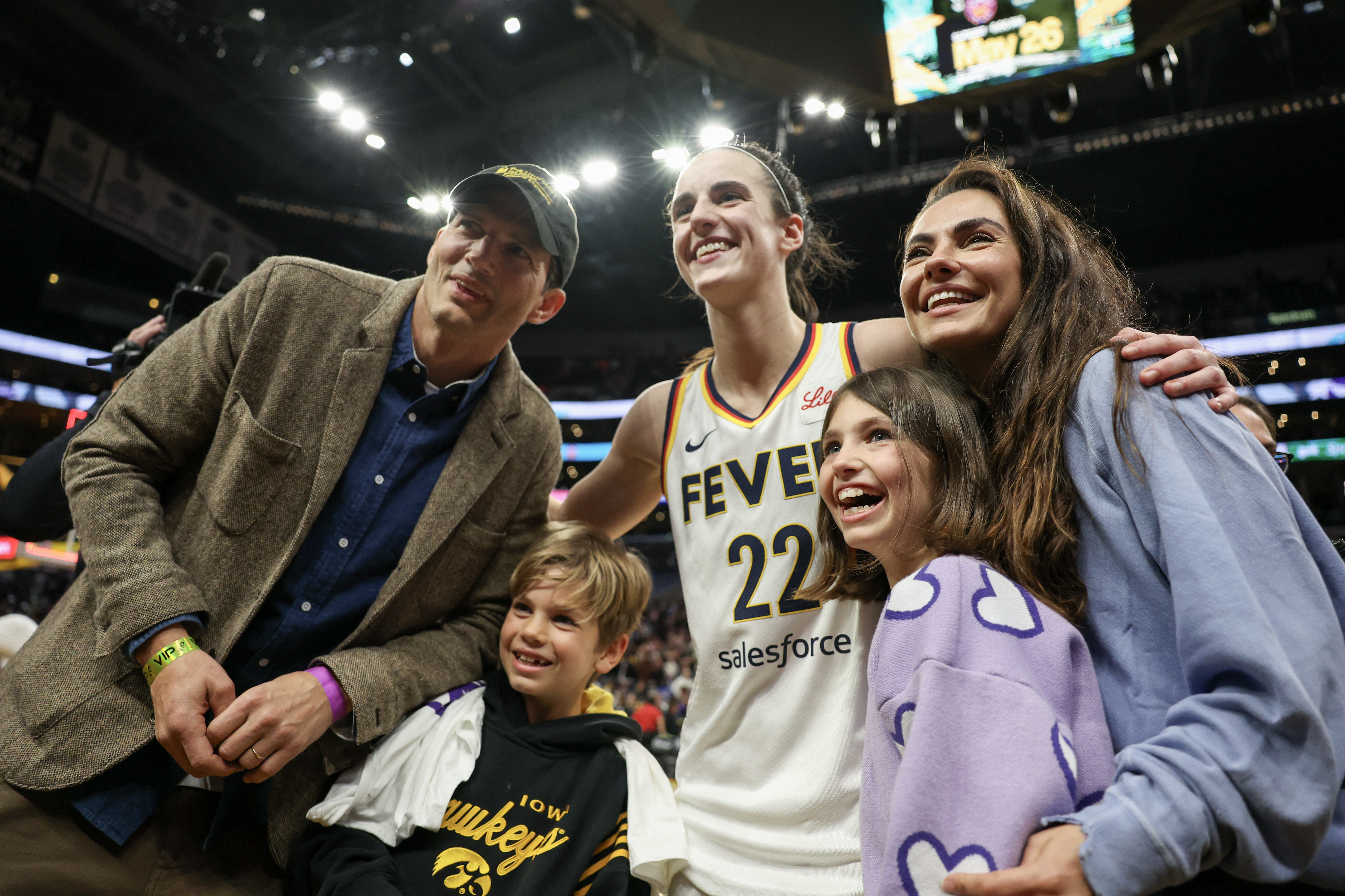 Ashton Kutcher e a atriz Mila Kunis com os filhos, Wyatt e Dimitri, e a jogadora de basquete Caitlin Clark 