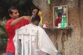 Homem corta o cabelo na rua