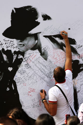 Fã escreve em painel em homenagem a Michael Jackson do lado de fora do Staples Center, em Los Angeles