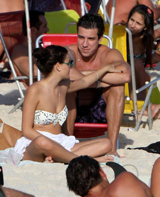 Isis Valverde com o namorado na praia da Barra da Tijuca