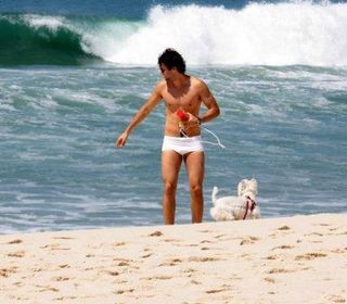 Gustavo Leão passeia com cachorro na praia