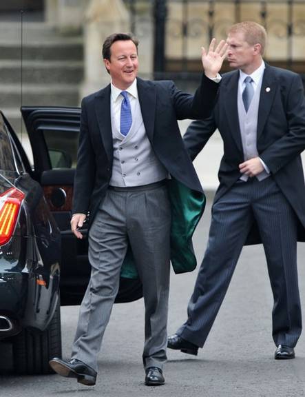 O primeiro-ministro David Cameron acena para as pessoas