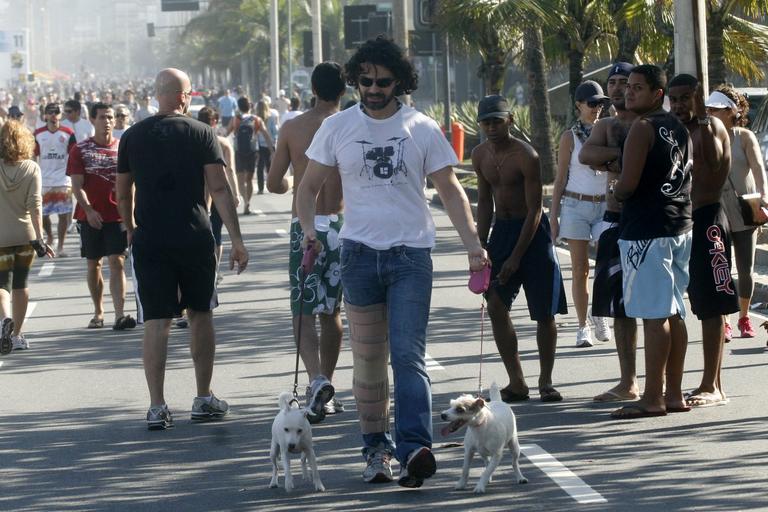 Carmo Dalla Vecchia caminha pela orla do Leblon, no Rio, com seus cachorrinhos