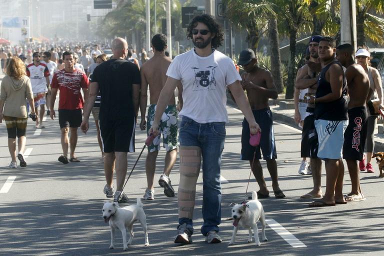 Carmo Dalla Vecchia caminha pela orla do Leblon, no Rio, com seus cachorrinhos